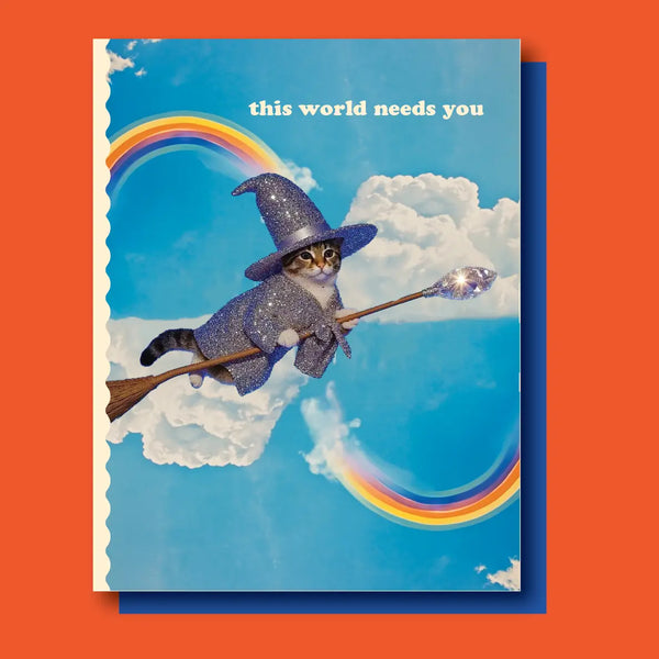 Card with a cat in a witch hat on a broomstick, rainbow, and 'this world needs you' text against a blue background with clouds. sparkle rainbow cat this world needs you greeting birthday support card magic cute funny pick up or delivery Pittsburgh Lawrenceville